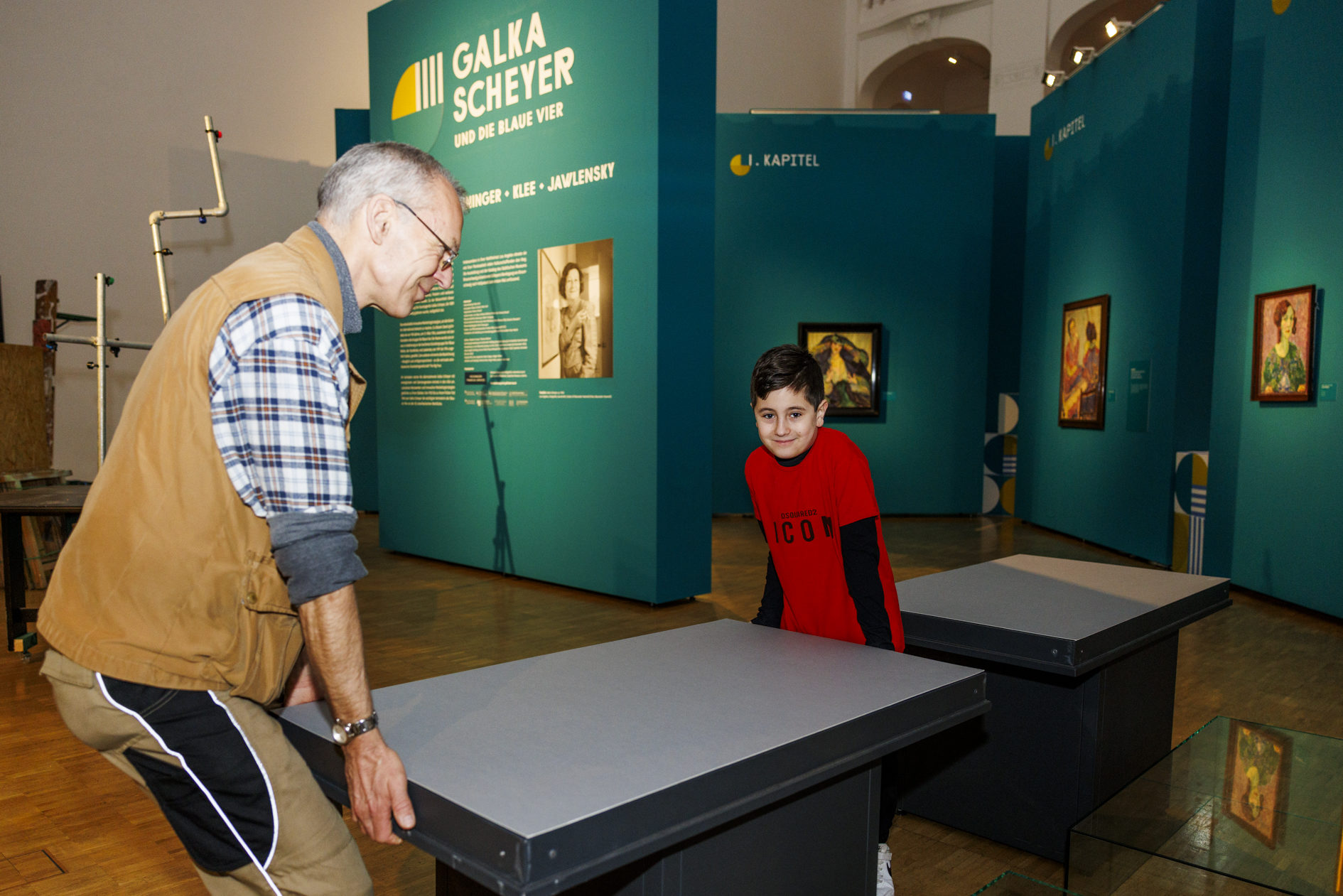 Zukunftstag im Städtischen Museum. Ein Junge hilft einem Mann beim Tragen eines Tisches. (Wird bei Klick vergrößert)